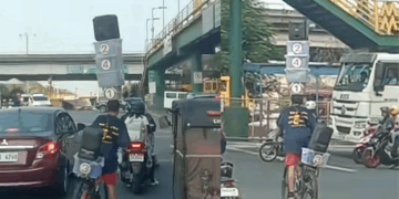 Delivery Rider in Manila Seen Balancing Boxes and a Speaker on His Head While Cycling Through Traffic