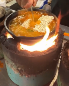 Claypot Maggi cooking over open flame