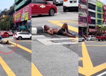 Man Casually Sleeps Under Traffic Light While Cars Keep Passing